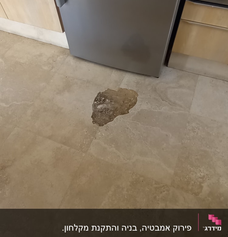 רצפה עם כתם רטיבות ליד מקרר נירוסטה